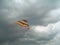 Colour bright flying kite against the storm sky