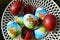 Colour Easter eggs in basket close up top view background, spring holiday