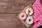 Coloured donuts, sprinkles hearts and smarties, wooden background