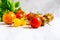 Coloured heirloom tomatoes on white marble bench with basil in background