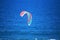 COLOURED KITE SURFER SAIL OVER BLUE SEA OFF THE COAST AT UMHLANGA ROCKS, KWA-ZULU NATAL, SOUTH AFRICA