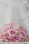 A coloured macro photo of a detailed bouquet with pink roses, white small flowers and a fake diamond in the centre of the roses, t