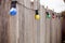 Coloured party lights strung along an old timber fence