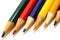Coloured pencils in colours green, red, blue, yellow, orange and black, aligned side by side in a closeup macro photo isolated