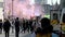 Coloured smoke released as people run to join the start of an Extinction Rebellion March on Parliament Street, London