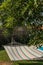 Coloured stripped hammock garden with swimming pool and wooden pergula