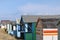 Colourful beach hut dwelling in a row on beach front.family holiday and storage icon