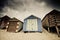 Colourful beach huts with dramatic sky