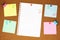 Colourful blank note paper on brown corkboard