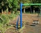 Colourful blue and green childrens swing in unused park during lockdown