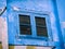 Colourful Blue Window with Shutters on A Street Art Wall