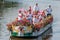 Colourful canal parade of flower and vegetables decorated boats with cheerful dressed up singing and dancing people