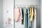 Colourful clothes on clothing rack, pastel colorful closet in shopping store or bedroom. Rainbow color clothes choice on hangers,
