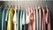 Colourful clothes on clothing rack, pastel colorful closet in shopping store or bedroom. Rainbow color clothes choice on hangers,