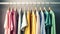 Colourful clothes on clothing rack, pastel colorful closet in shopping store or bedroom. Rainbow color clothes choice on hangers,