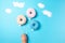 Colourful donuts on blue background, creative food minimalism, donuts in a shape of balloon in the sky with clouds made of sugar