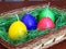 Colourful egg shaped candles in a basket. Easter home decoration.