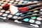 Colourful eye shadows palette with brushes. Makeup background. Professional cosmetics for darkening and thickening eyelashes