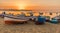 Colourful fishing boats pulled onto the beach Aspra Sicily at sunset