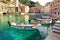 Colourful fishing boats in small marina of Vernazza, one of the five centuries-old villages of Cinque Terre, located on rugged