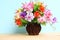 Colourful flower bunch in wood vase on wooden table and copy space