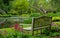 Colourful flowers and shrubs grow around the lake at the John Lewis Longstock Park Water Garden, Hampshire UK