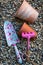 Colourful garden tools with terracotta clay flower pots on a gravel background