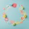 Colourful handmade tropical paper flowers and leggs on blue pastel background with copyspace, seasonal easter wreath, summer