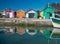 Colourful harbour with wooden fishing huts reflection in water