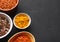 Colourful indian condiments in bowls on background