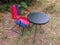 Colourful outdoor set of a red and purple chair and a black table