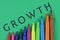 Colourful pen with growth wording on green background. Business, economy and motivational concept