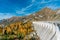 Colourful picture of the reservoir dam at the Fedaia lake in South Tyrol in autumn
