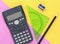 Colourful pink and yellow desk flat lay with calculator