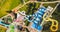 Colourful plastic slides in aquapark. Sliders with pool. Enjoying summer vacation in water park. Aerial view of aqua park