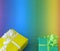 Colourful presents in yellow and green in front of a blue green yellow orange red background