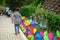 Colourful rainbow pinwheel in the park with people walking along the pathway.