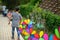 Colourful rainbow pinwheel in the park with people walking along the pathway.