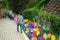 Colourful rainbow pinwheel in the park with people walking along the pathway.