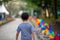 Colourful rainbow pinwheel in the park with people walking along the pathway.