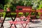 Colourful red bistro tables and chairs belonging at a cafe in a garden at Hartley Wintney, Hampshire, UK.