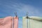 Colourful red and green teatowels hang on a washing line with stainless steel pegs