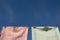 Colourful red and green teatowels hang on a washing line with stainless steel pegs