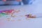 Colourful shavings on white table, sharpening pencil sharp knife, hands closeup.