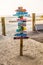 Colourful signpost pointing in different directions at the beach