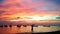 Colourful sky reflects with the sea and taxi boats along the bay