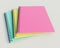 Colourful stacked spiral binder notebooks. Blank notebooks. Side view. 3D rendering illustration.