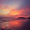 Colourful sunset reflecting in low tide puddles on the beautiful beach in Krabi Island, Thailand.