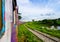 A colourful train going around a bend with grassy banks surround