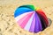 Colourful umbrella and sand background